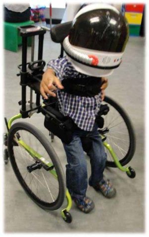Photo of young child wearing a helmet in a mobile stander