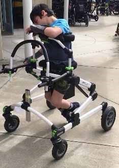 Photo of young boy ambulating in a mobile stander